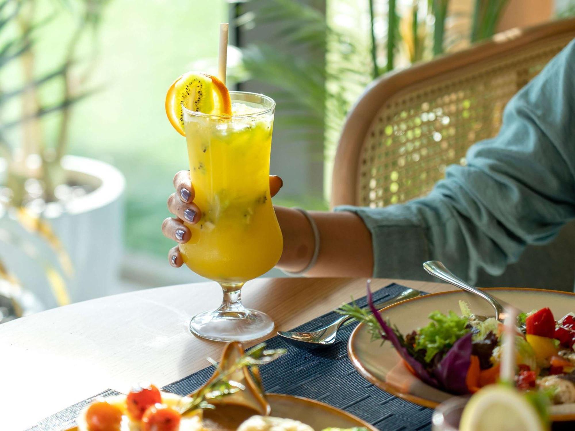 Swissotel Living Джеда Екстериор снимка A woman holding a glass of juice
